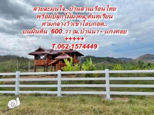 For SaleLandNakhon Nayok : Beautiful, empty land 600.wa. with a Thai style wooden house amidst a view of Khao Lamunjai. T.062-1574449